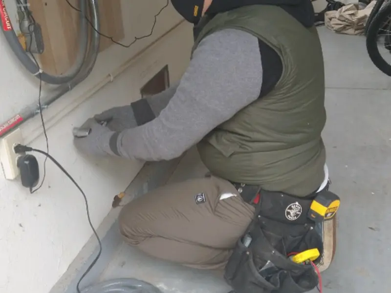 Electrician performing outlet wiring in a Murray garage
